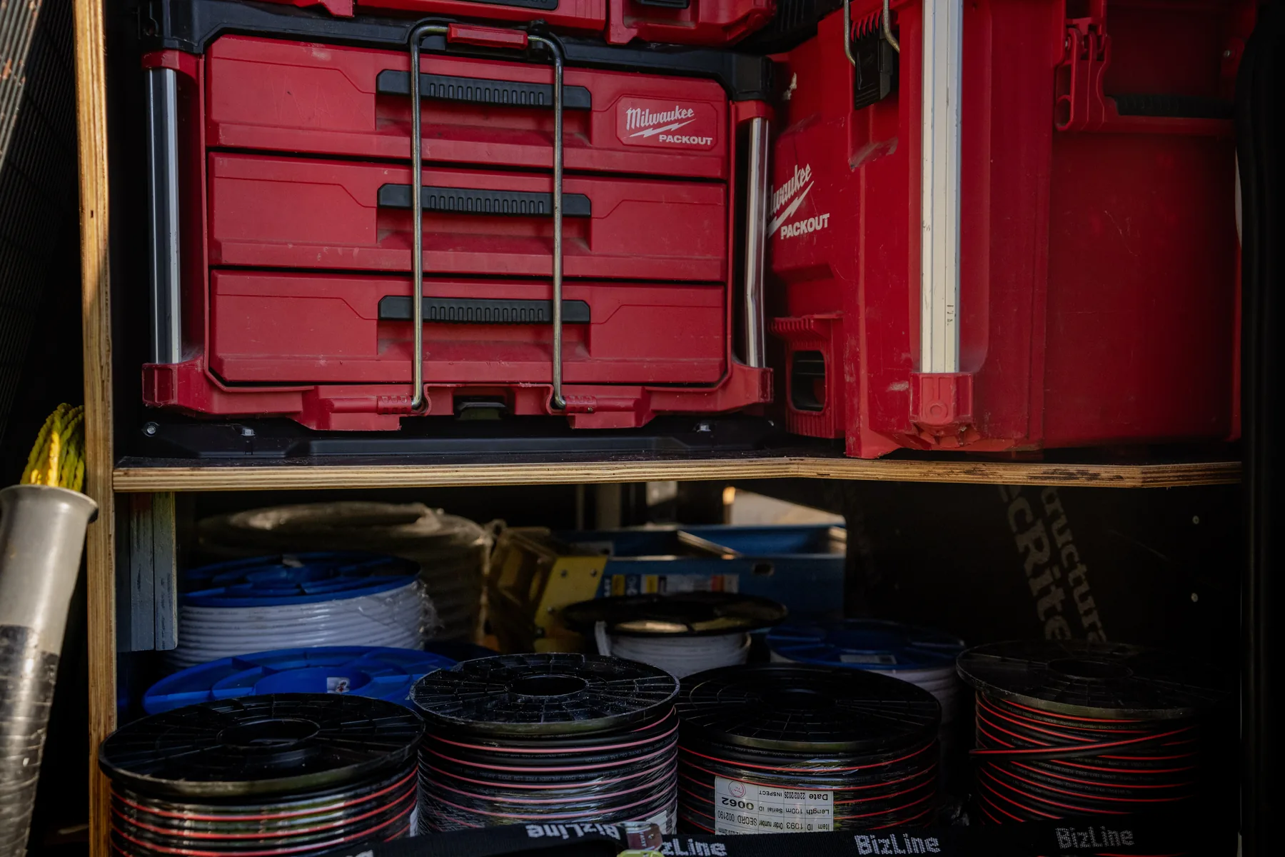 Plywood shelving holding toolboxes and cable reels