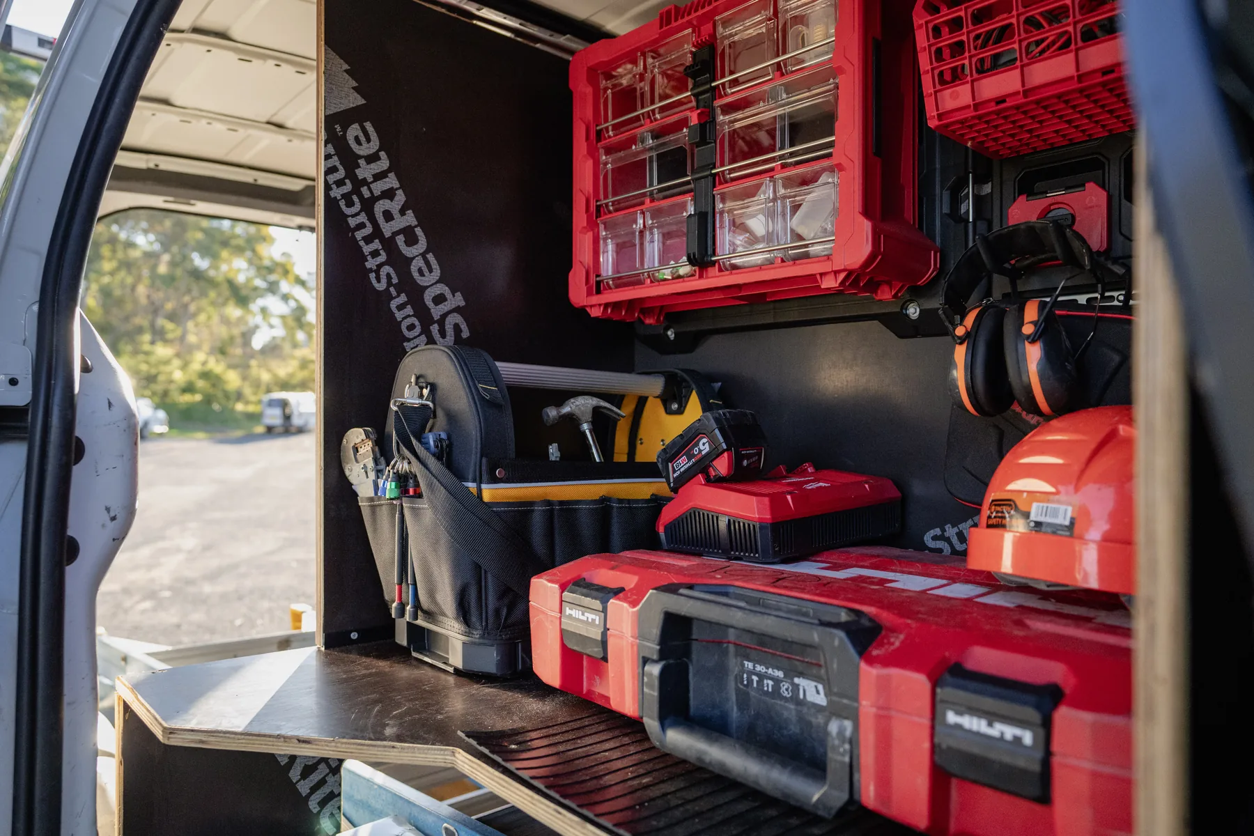 Wide view of a finished plywood van fitout with a mounted toolbox wall