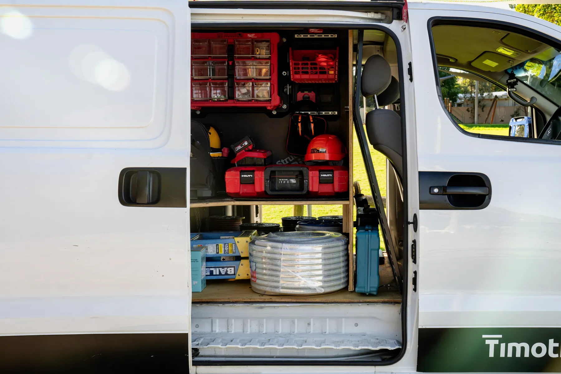 Trade van with the side door open showing a completed Vanworks fitout