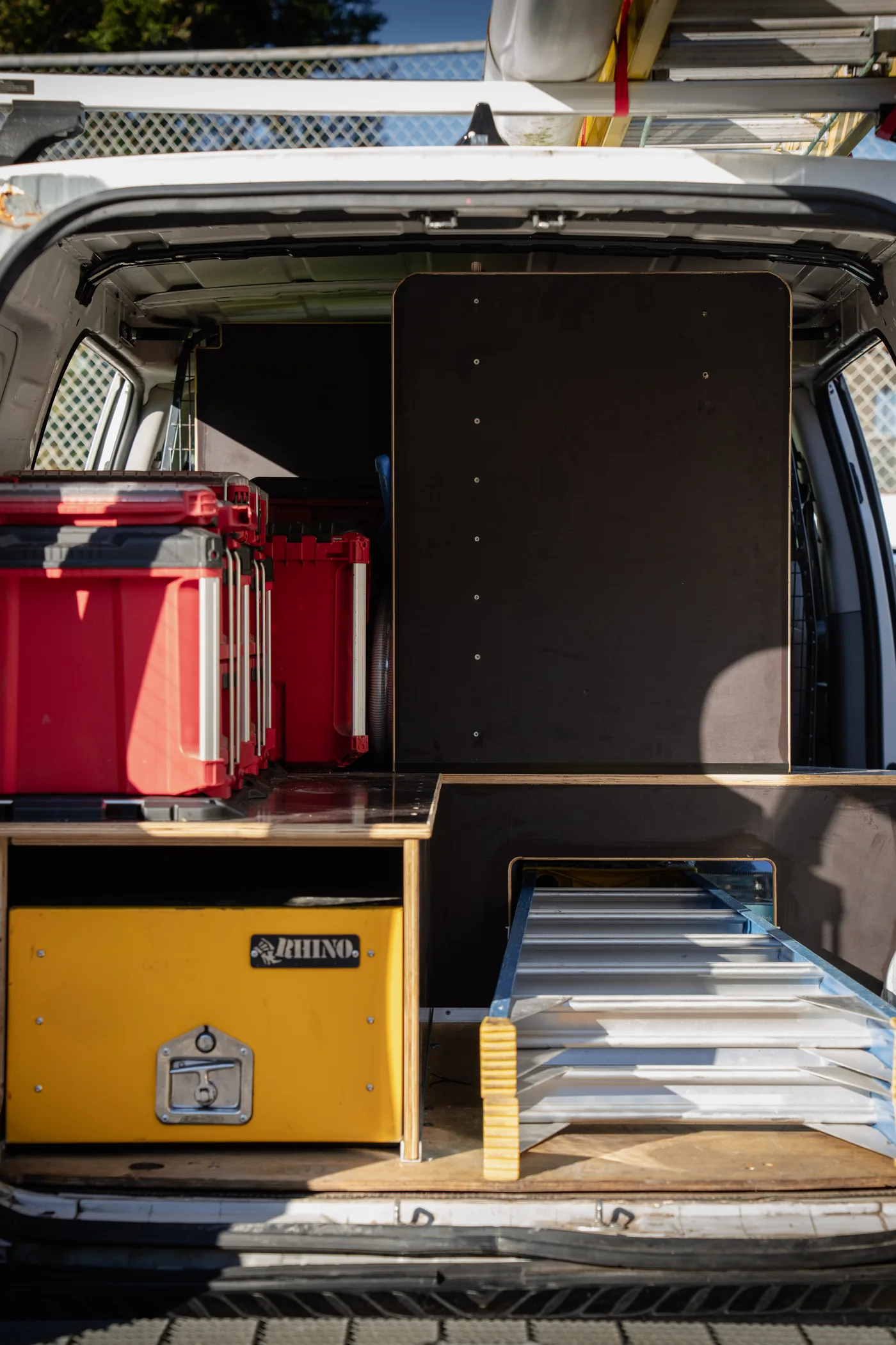 Rear of a van showing drawer storage and ladders stowed inside