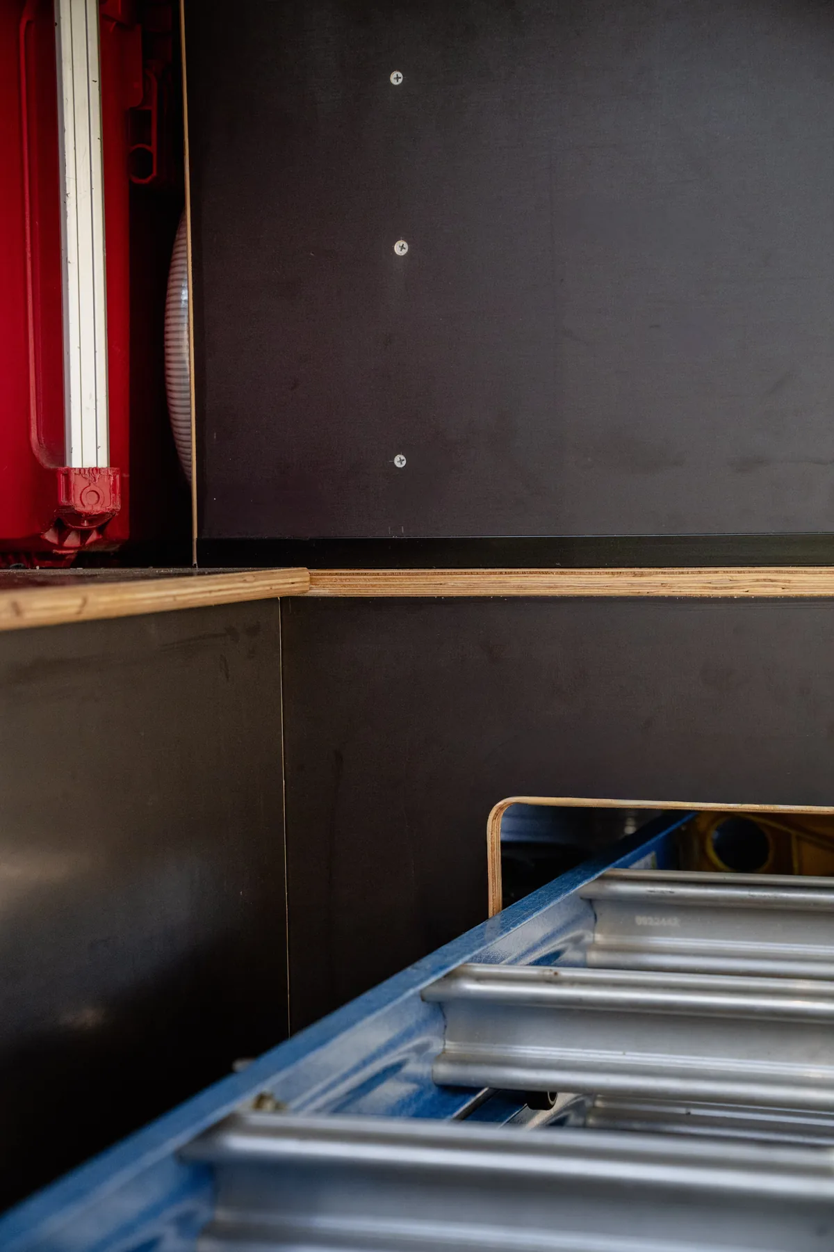 Ladder stored on a slide inside a van fitout